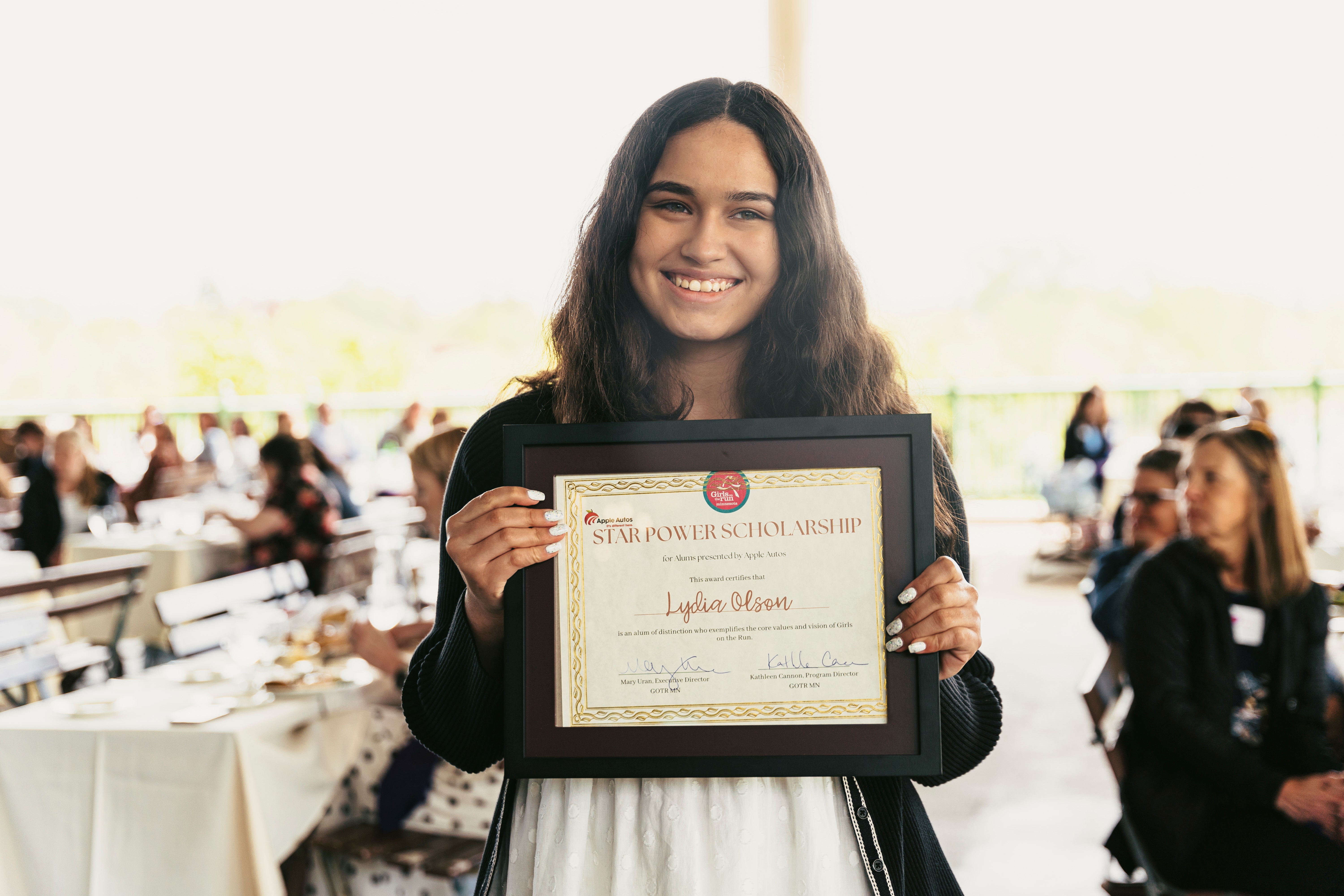 2022 Scholarship Winner Smiling with a framed certificate