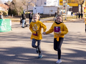 Two Girls on the Run participants smile and hold hands as they head to the finish line